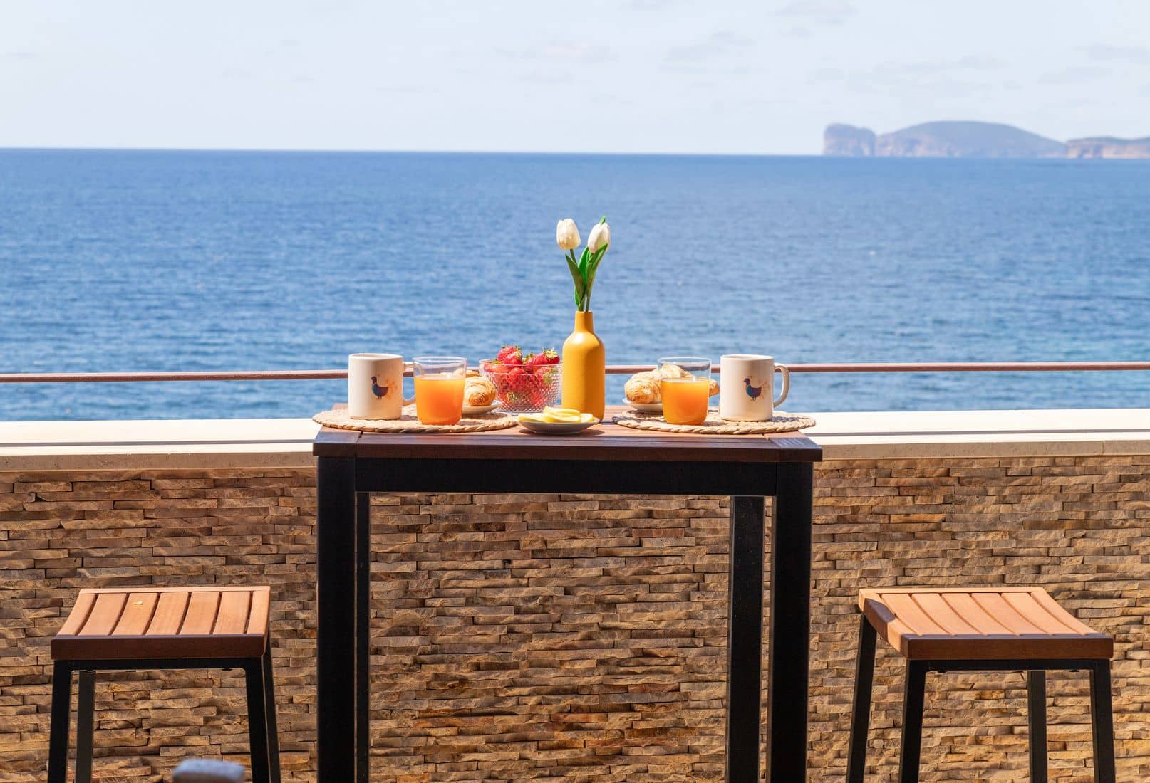 Morning breakfast on the sea view terrace of an Alghero apartment overlooking Capo Caccia, Sardinia. Colazione mattutina sulla terrazza vista mare di un appartamento ad Alghero con vista su Capo Caccia, Sardegna.